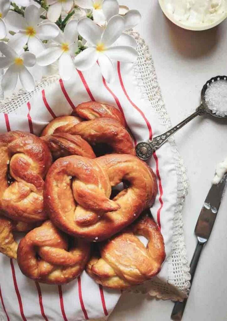 Freshly baked homemade sweet pretzels in Lahore served on cloth with sugar and butter knife.