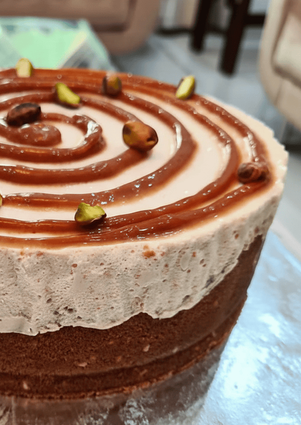 Homemade pistachio caramel cake in Lahore with creamy layers and caramel swirl topping on cake base.