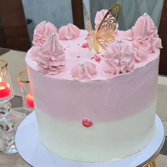 Pink butterfly birthday cake with pastel frosting and gold topper – homemade custom cake in Lahore