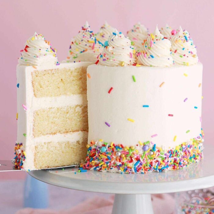 Homemade vanilla birthday cake with white frosting colorful sprinkles and soft sponge available in Lahore