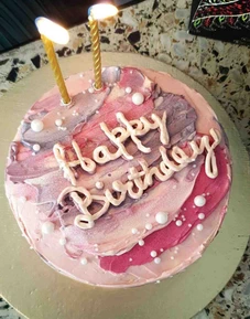 Custom homemade birthday cake in Lahore with pink artistic frosting and happy birthday message.